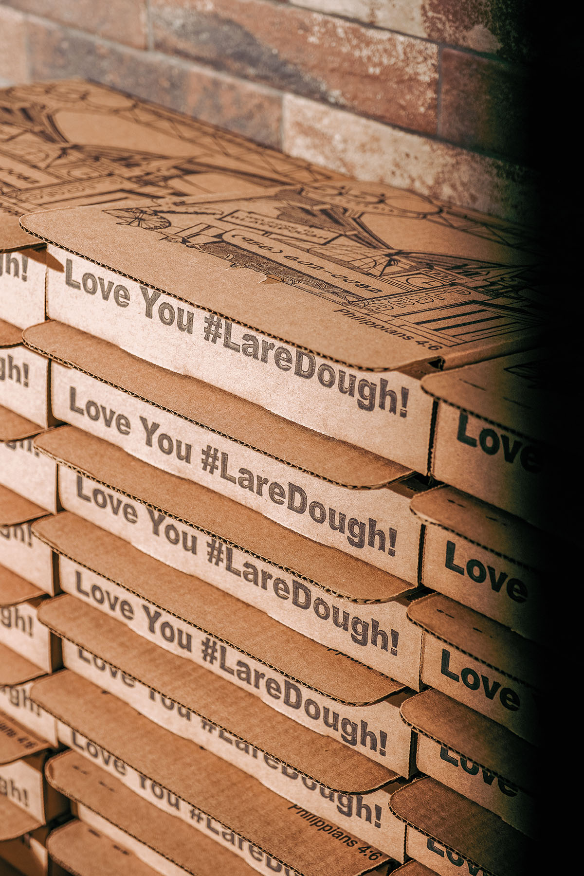 A stack of cardboard pizza boxes labeled with 