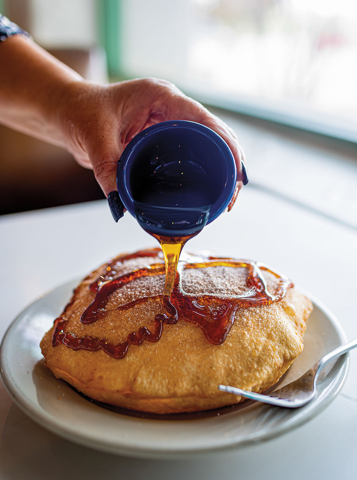 A caramel-colored sauce is poured on a puffed, golden brown pastry