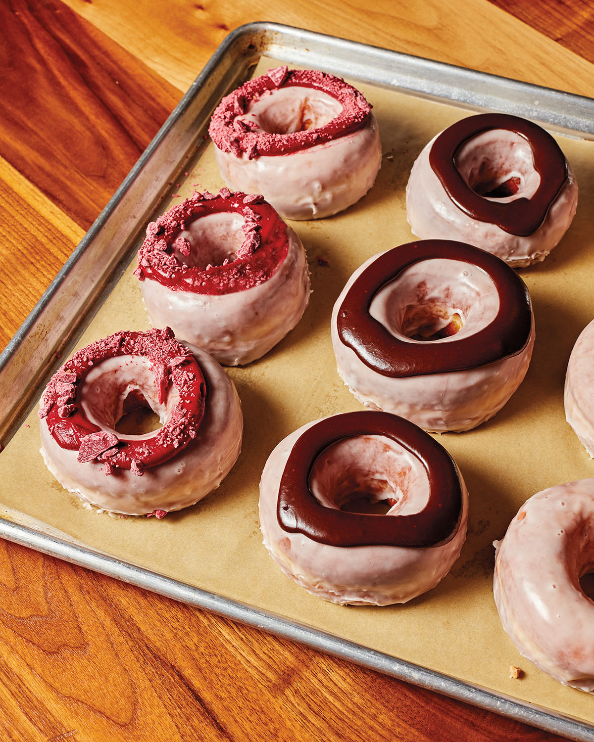 Bright pink donuts topped with pink and chocolate frosting