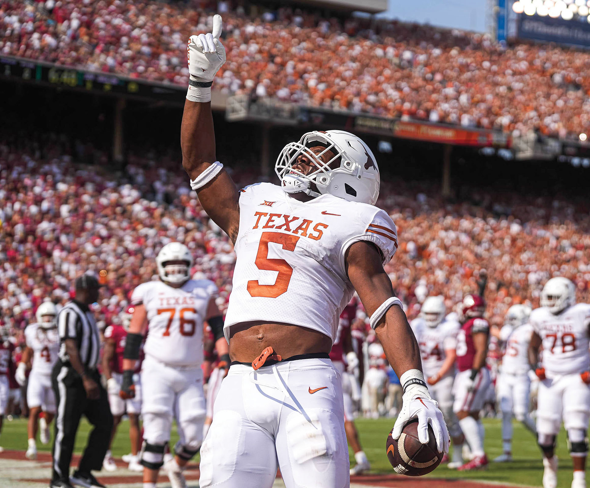 A person wearing a Texas Longhorns no. 5 jersey points his finger to the sky