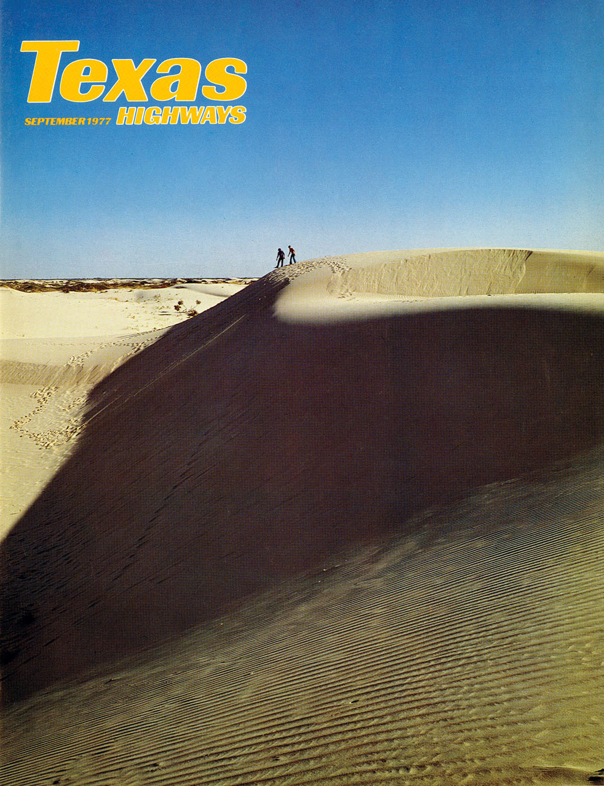 A cover of Texas Highways with a blue background and large sand dune on the cover