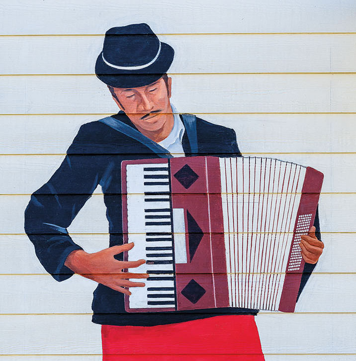 A painted mural of a man in a hat playing accordion