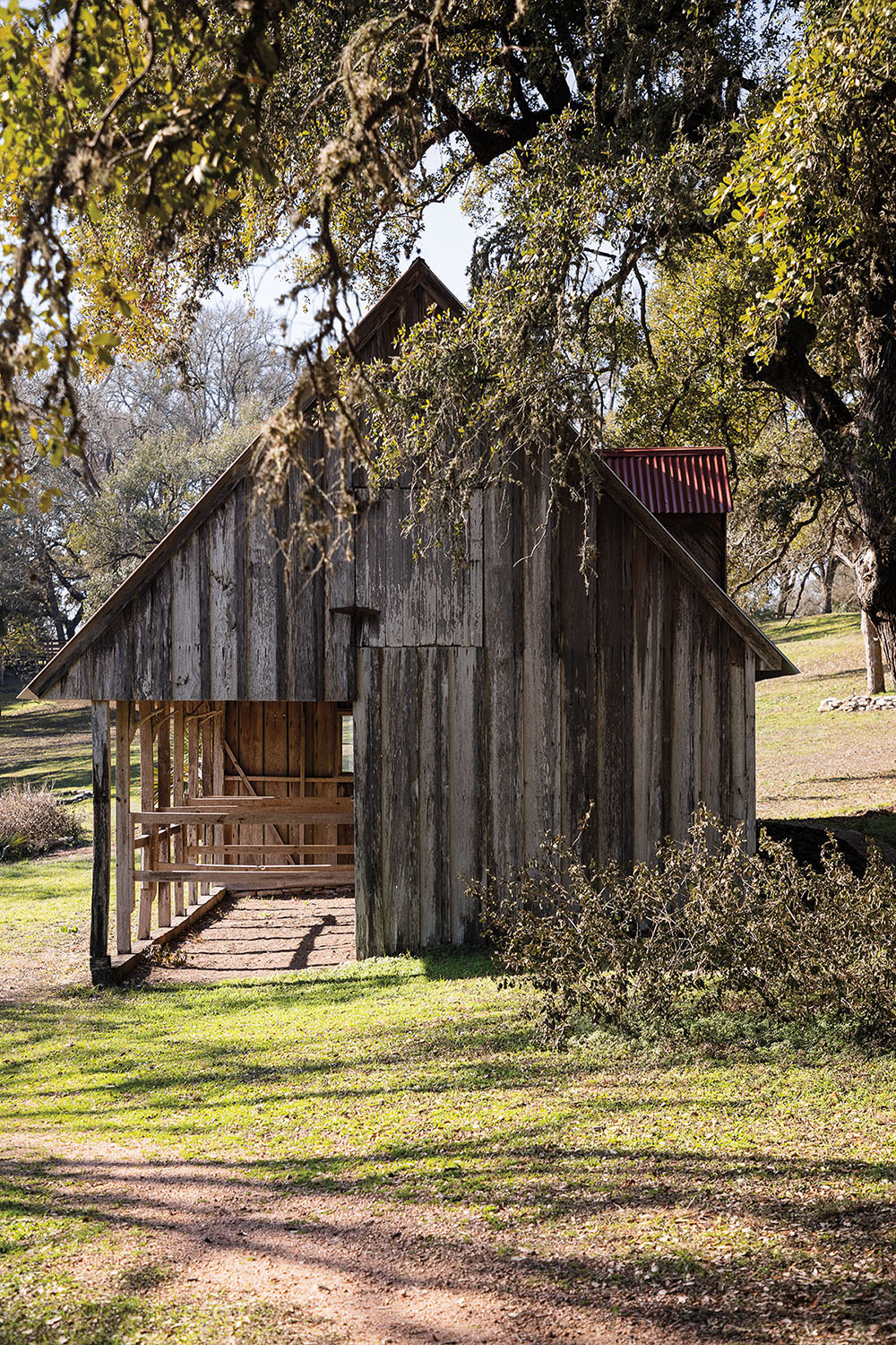 The exterior of a wooden barn and green grass
