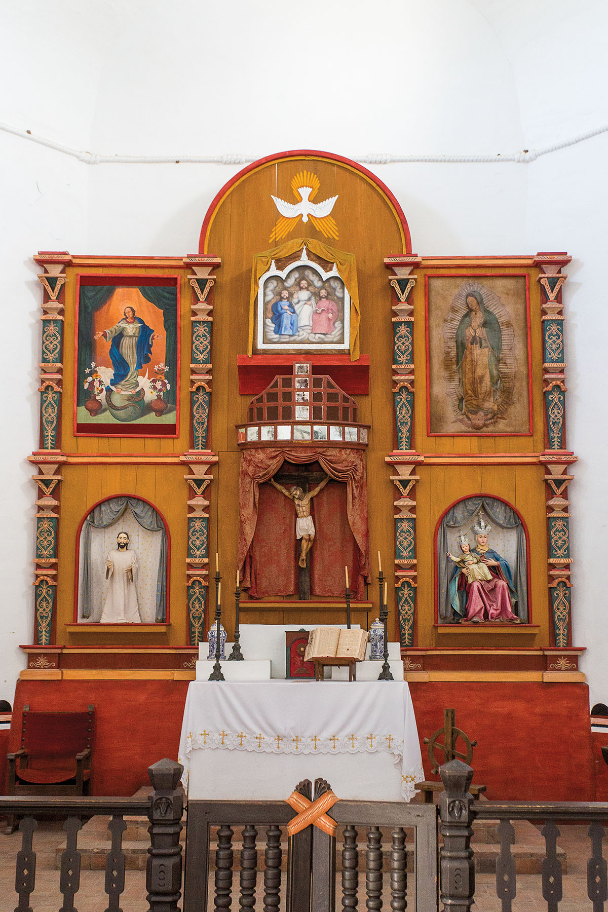 An ornate altar with drawings and a statue of Jesus