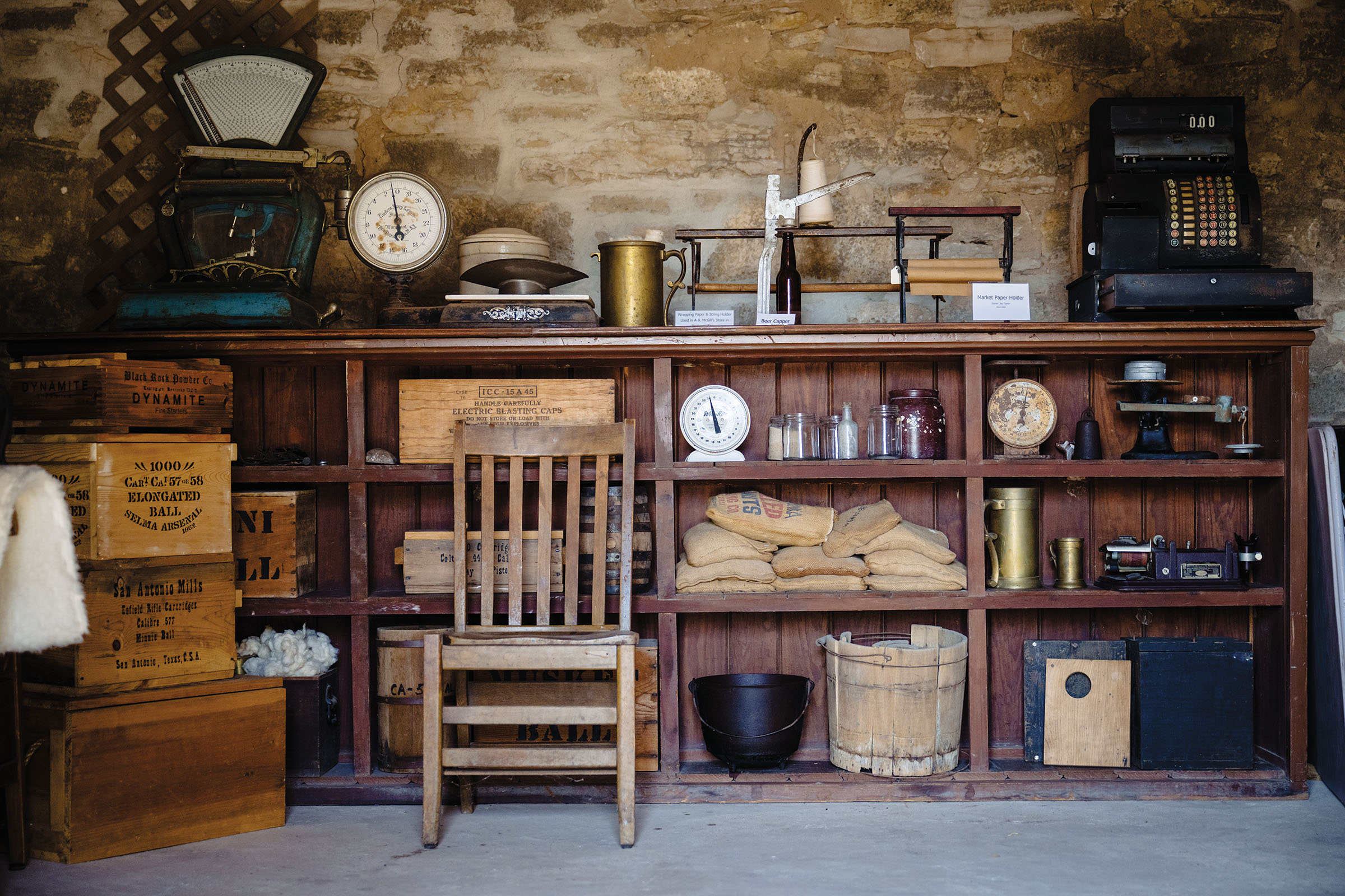 Wooden bookshelves and a chair inside of a historic stone building