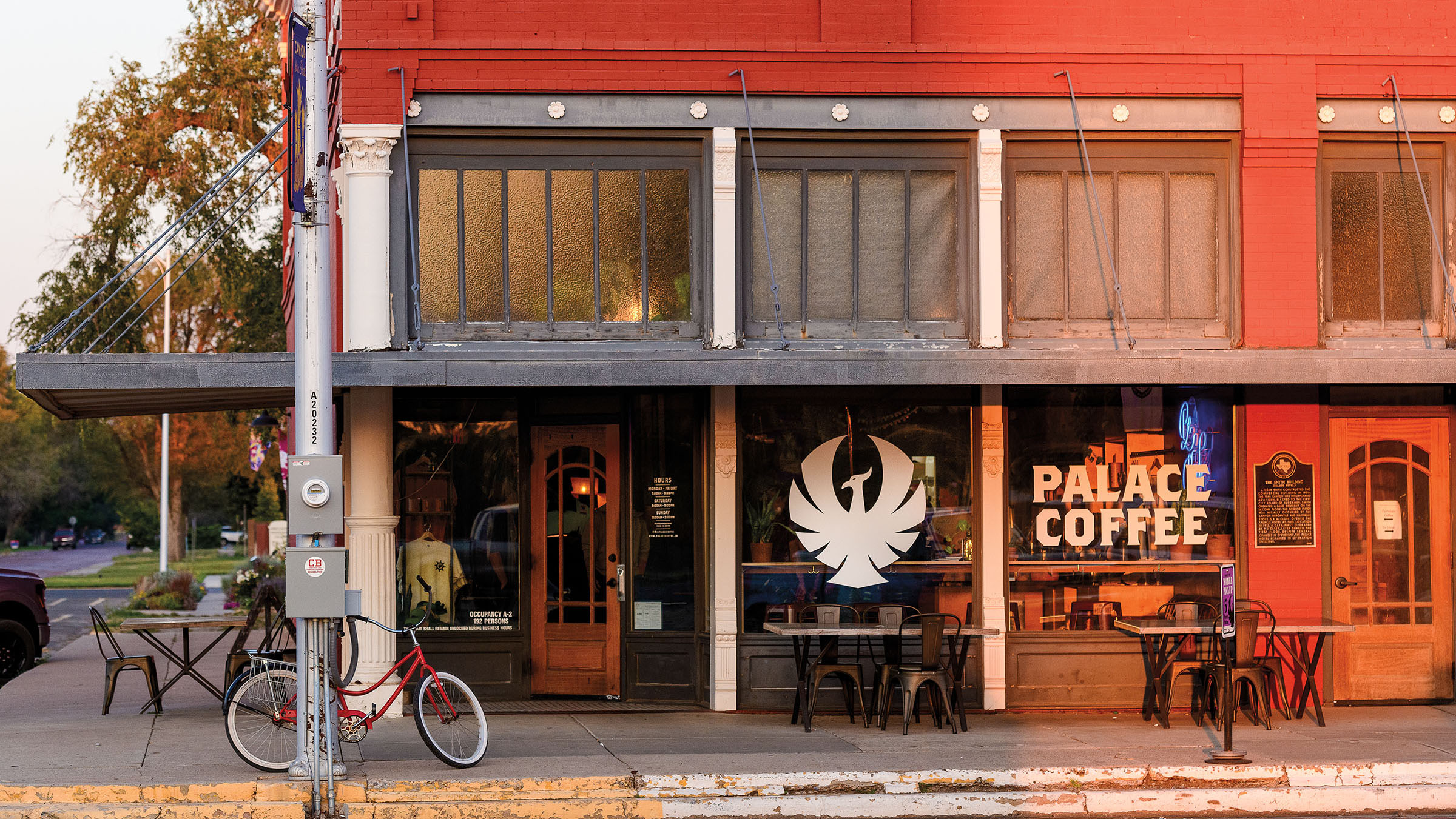 The exterior of a coffee shop with a bird-like figure painted on the window outside