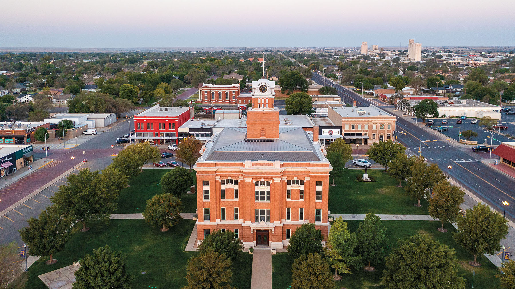 An overhead view of a red stone courthouse in a green lush area
