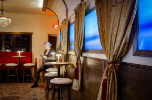 A woman sits a table in a room that looks like a train car