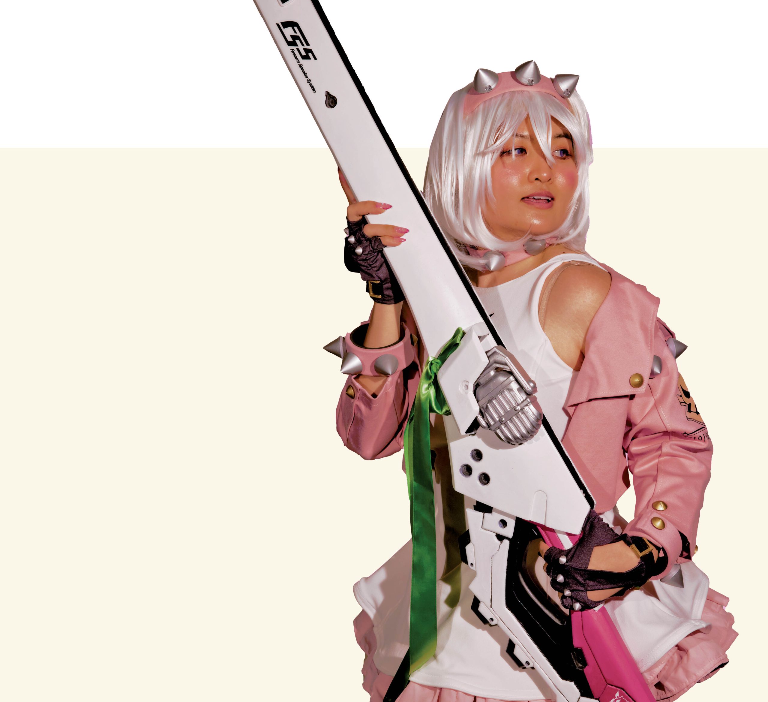 A woman with white hair holding a guitar poses for the camera