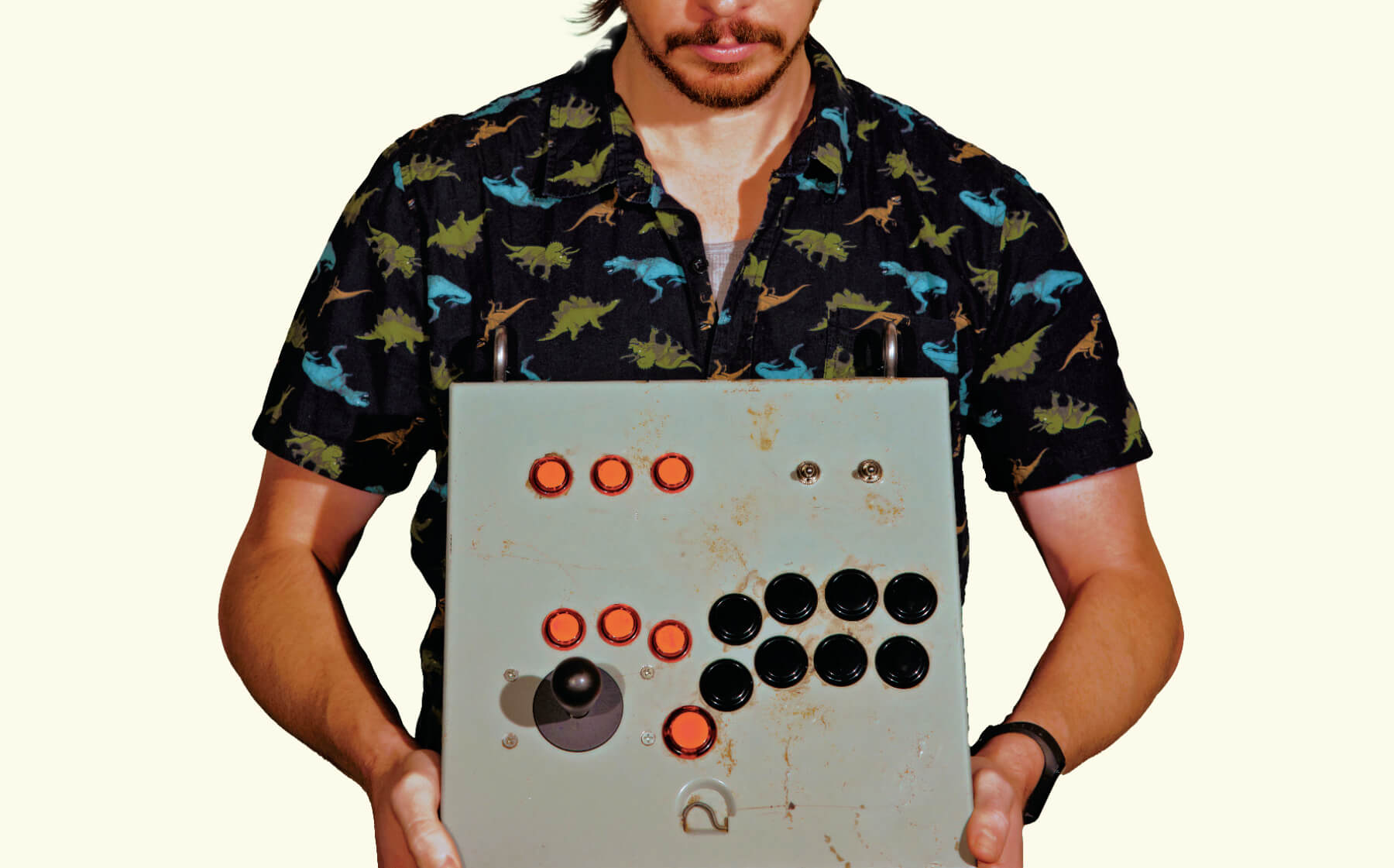 A photo of a person holding a silver electronic device with black and red buttons