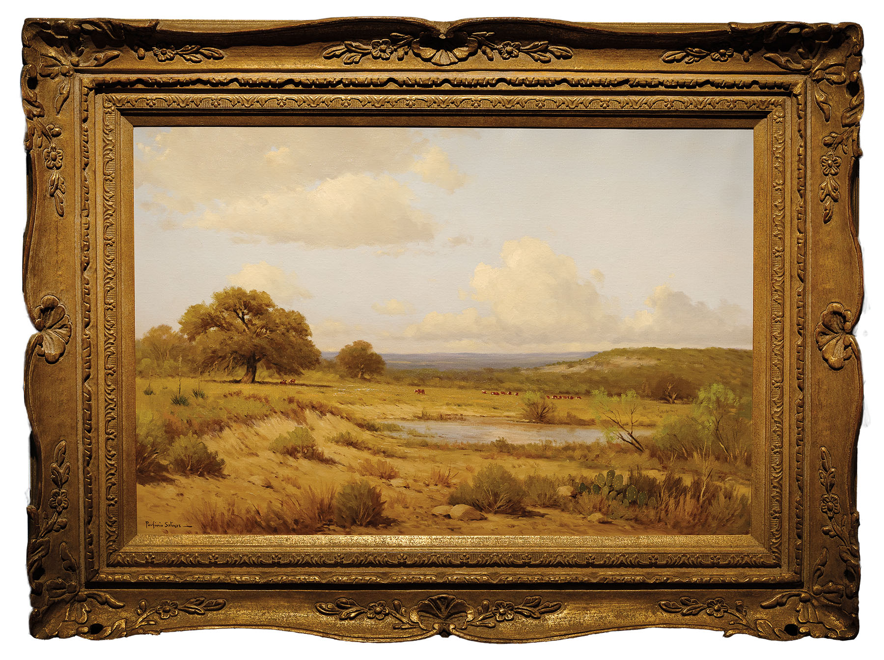 A landscape painting in an ornate gold frame