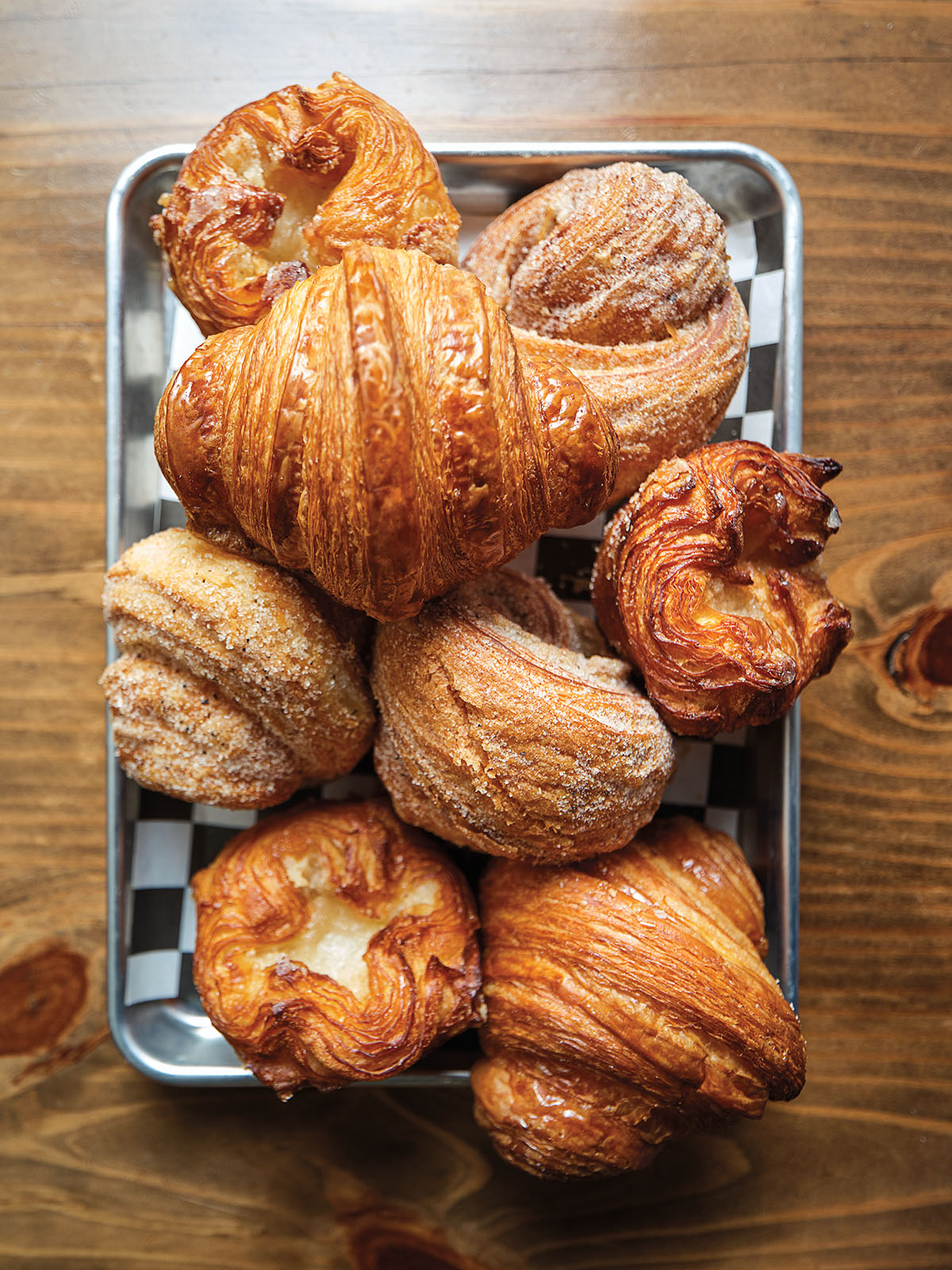 An overhead view of a platter of croissants and other baked goods