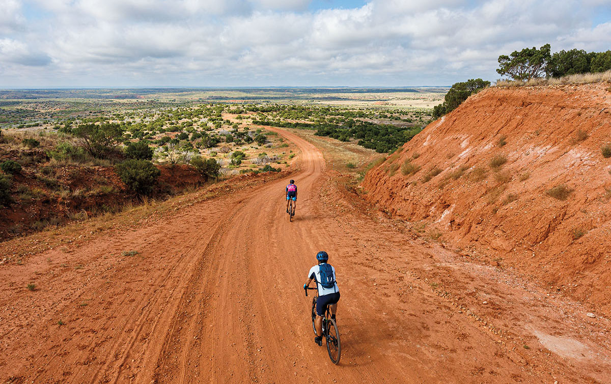 A person riding a bike in a dust-red landscape