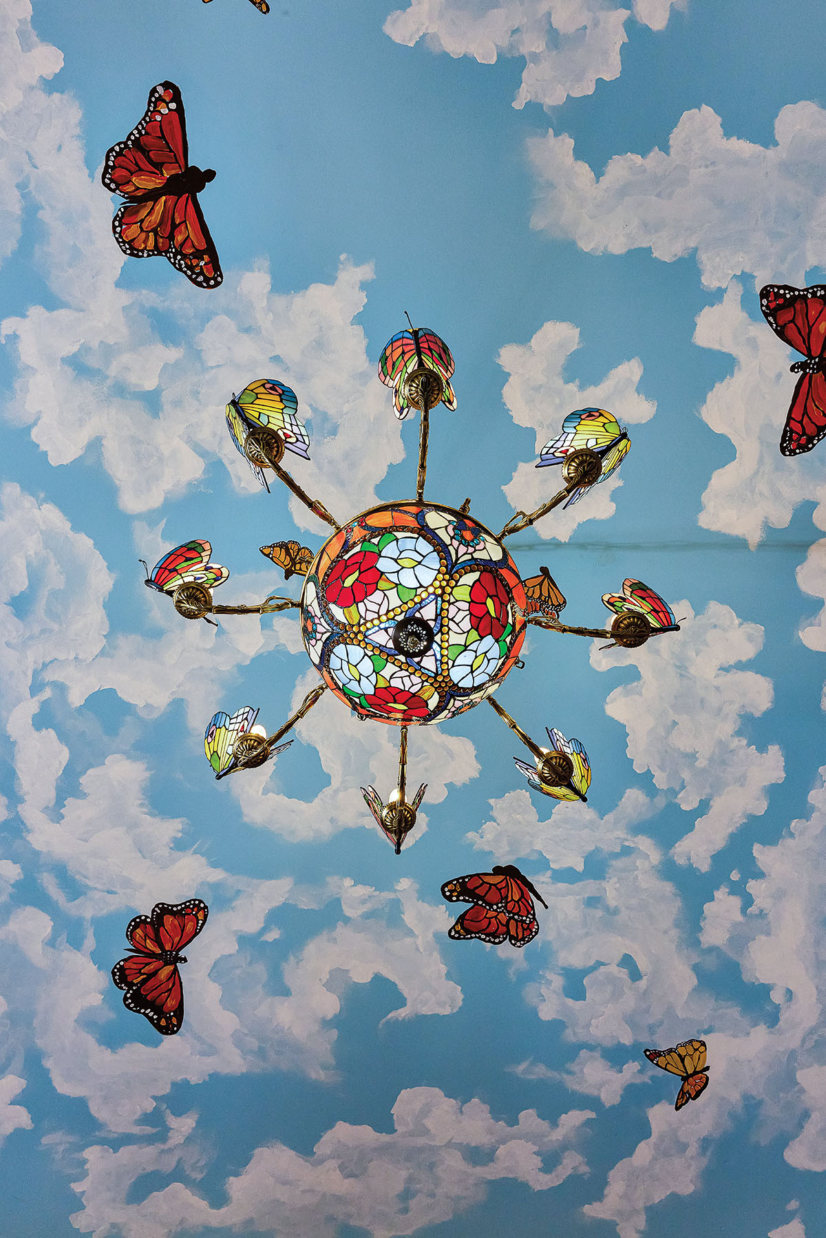 A brightly-painted ceiling with butterflies and clouds