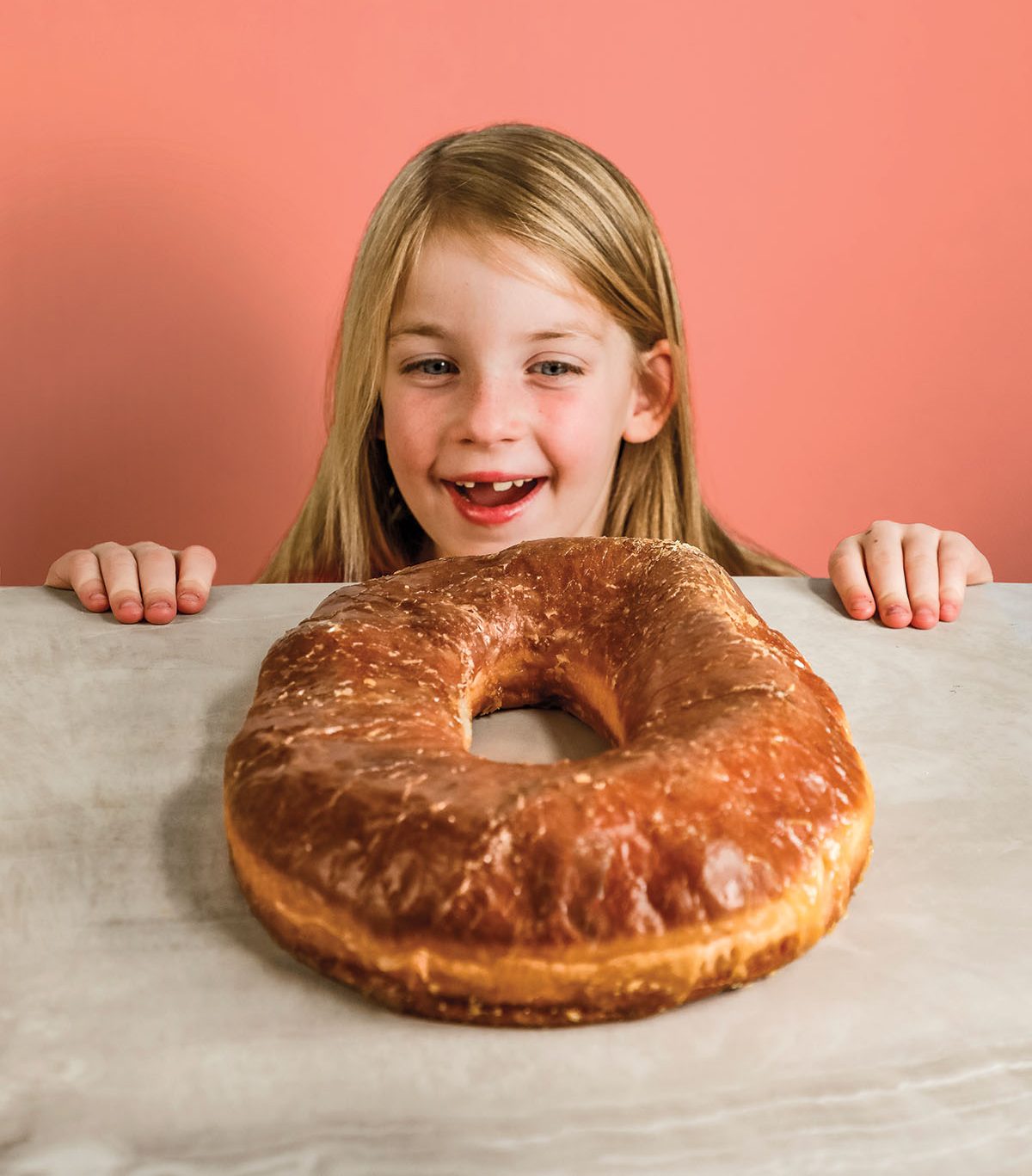 Photo of a child smiling at a large donut from Round Rock and Cedar Park