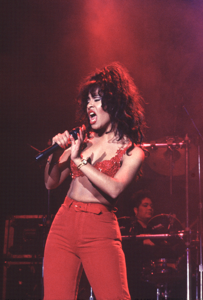 Selena singing onstage in a red outfit