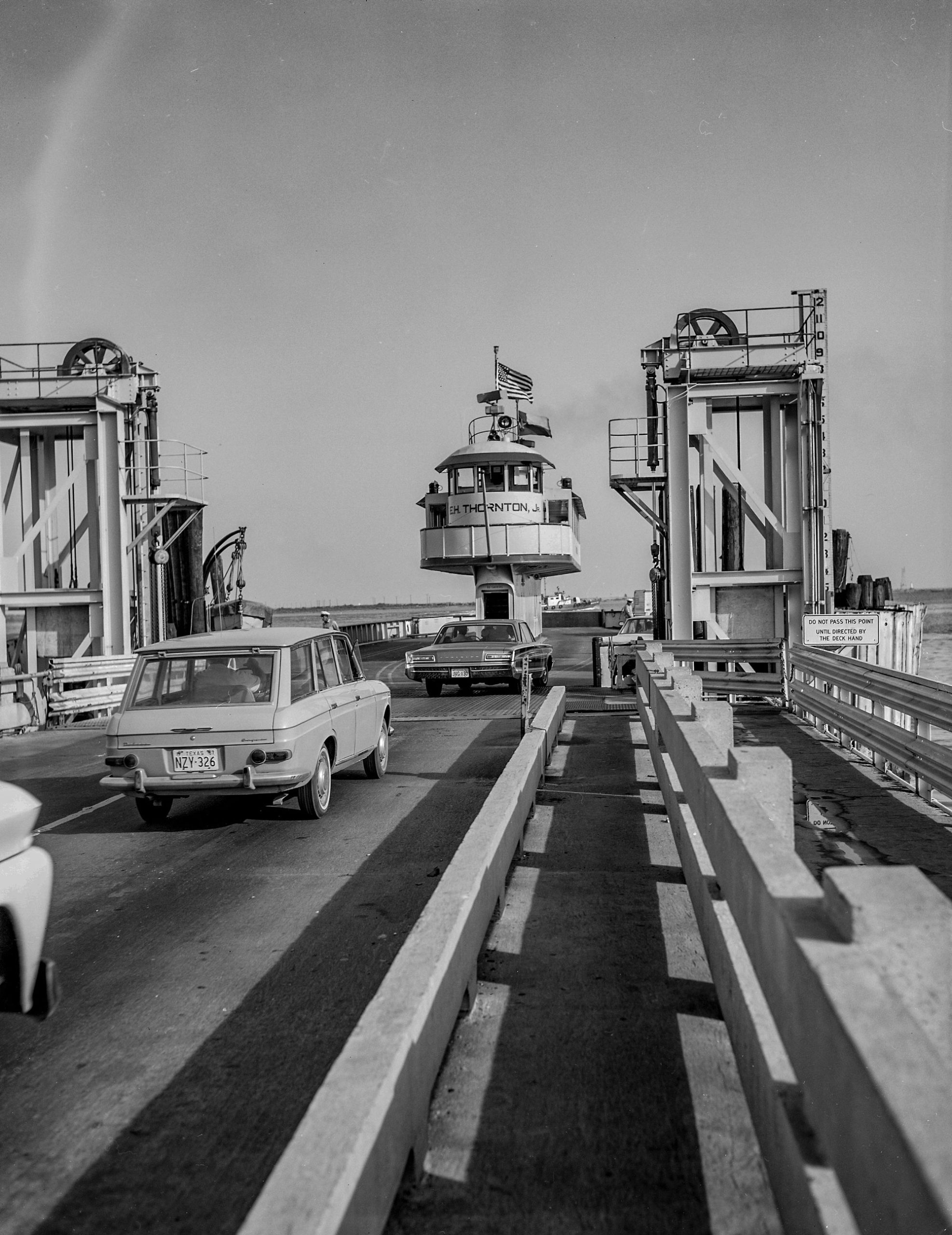 Cars loading onto a ferry in a black and white image