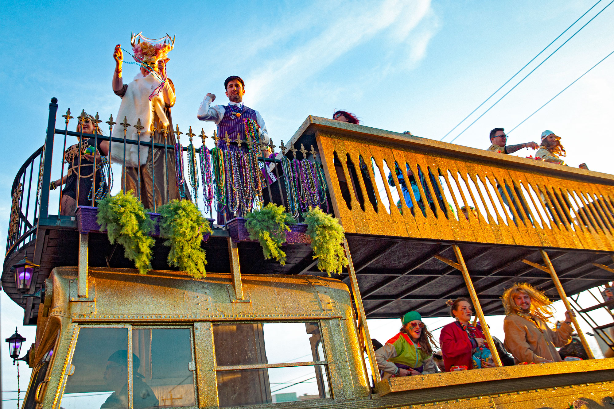 People stand on a yellow party bus in Mardi Gras decor