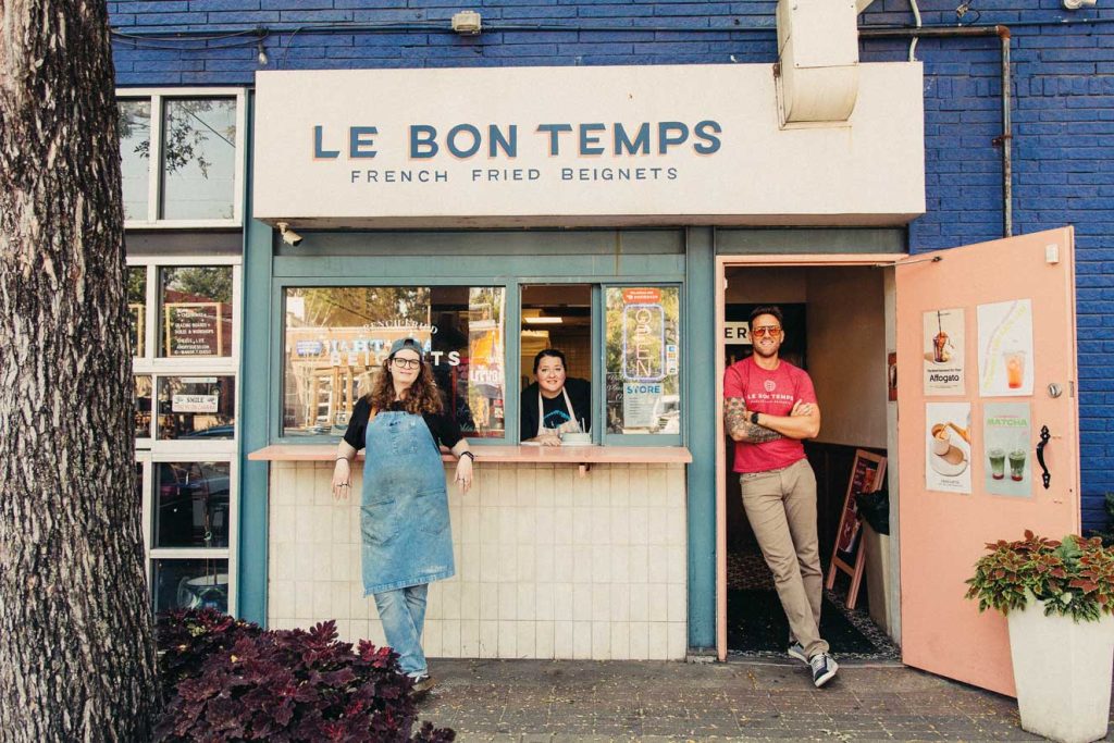 Three people at the front of a bakery