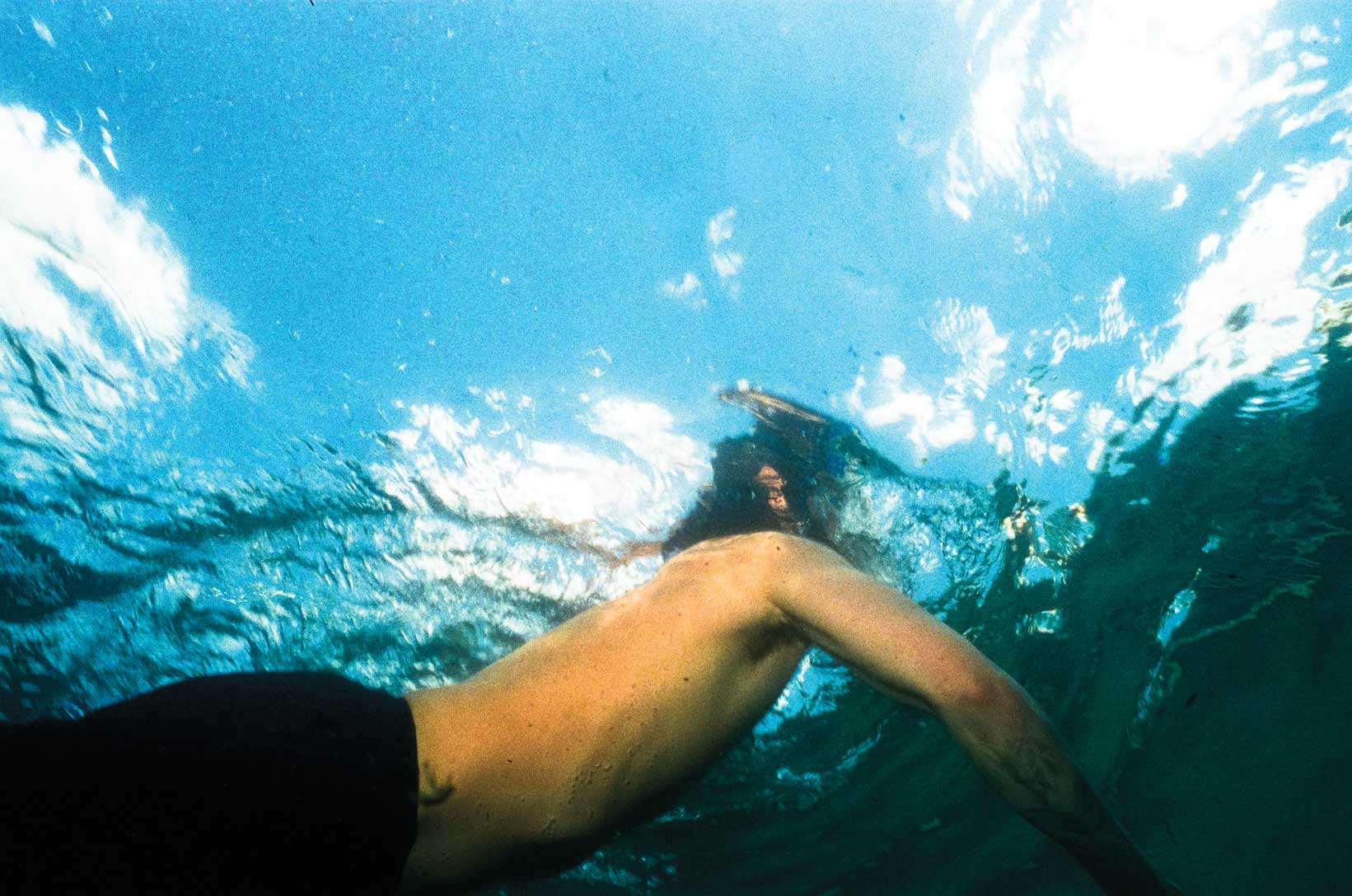 The view from underwater of a man swimming