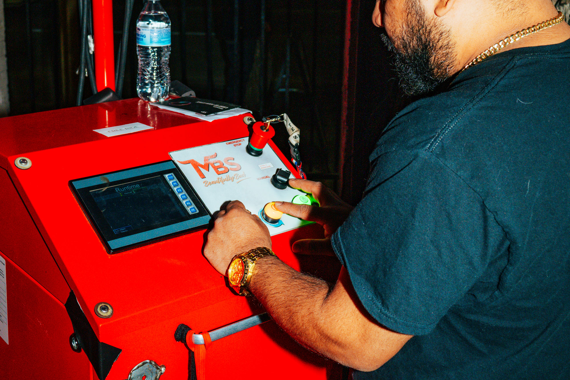 A man operates a red machine with a screen and buttons