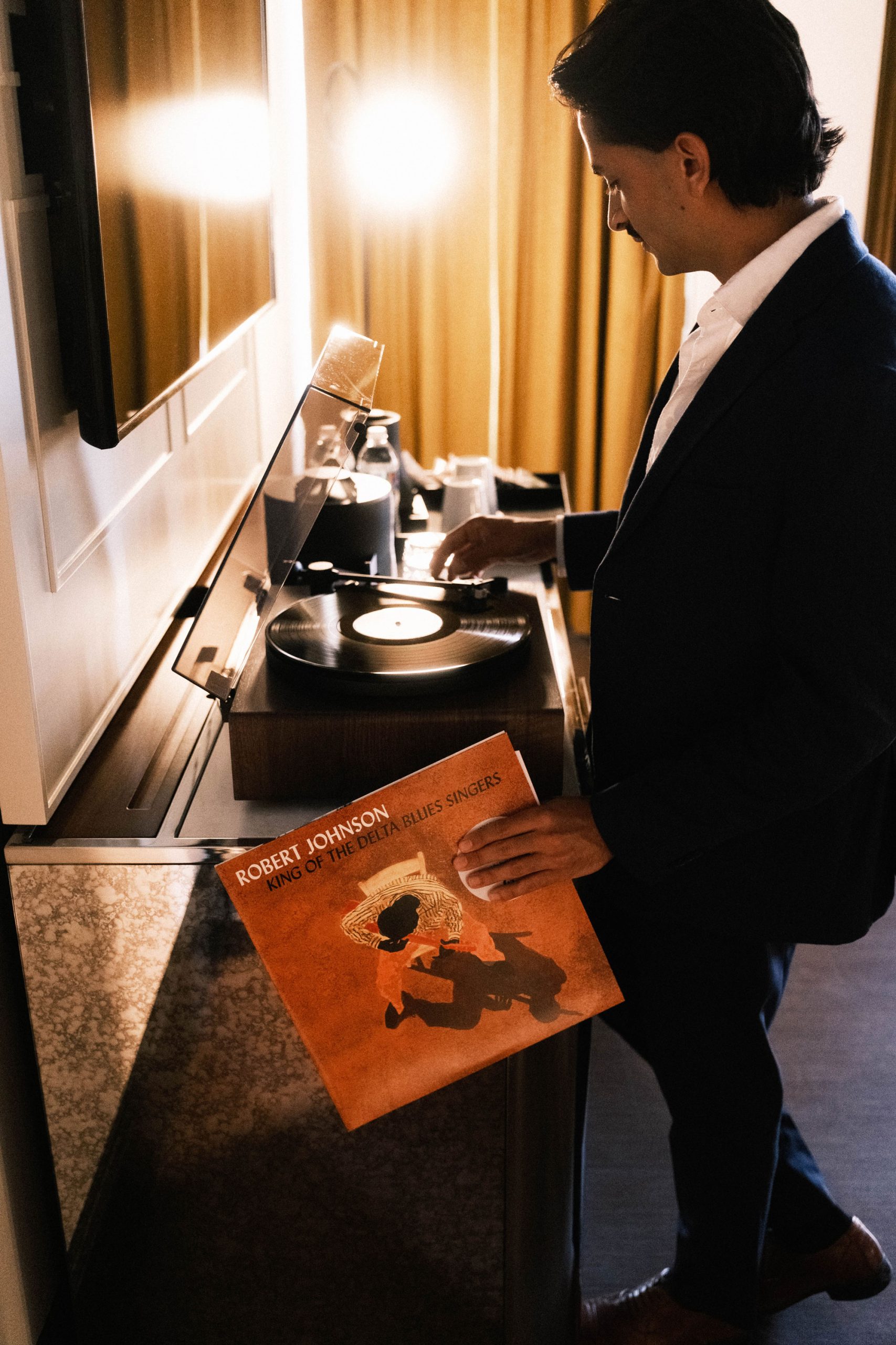A person playing the Robert Johnson King of the Delta Blues Singers record in a hotel room