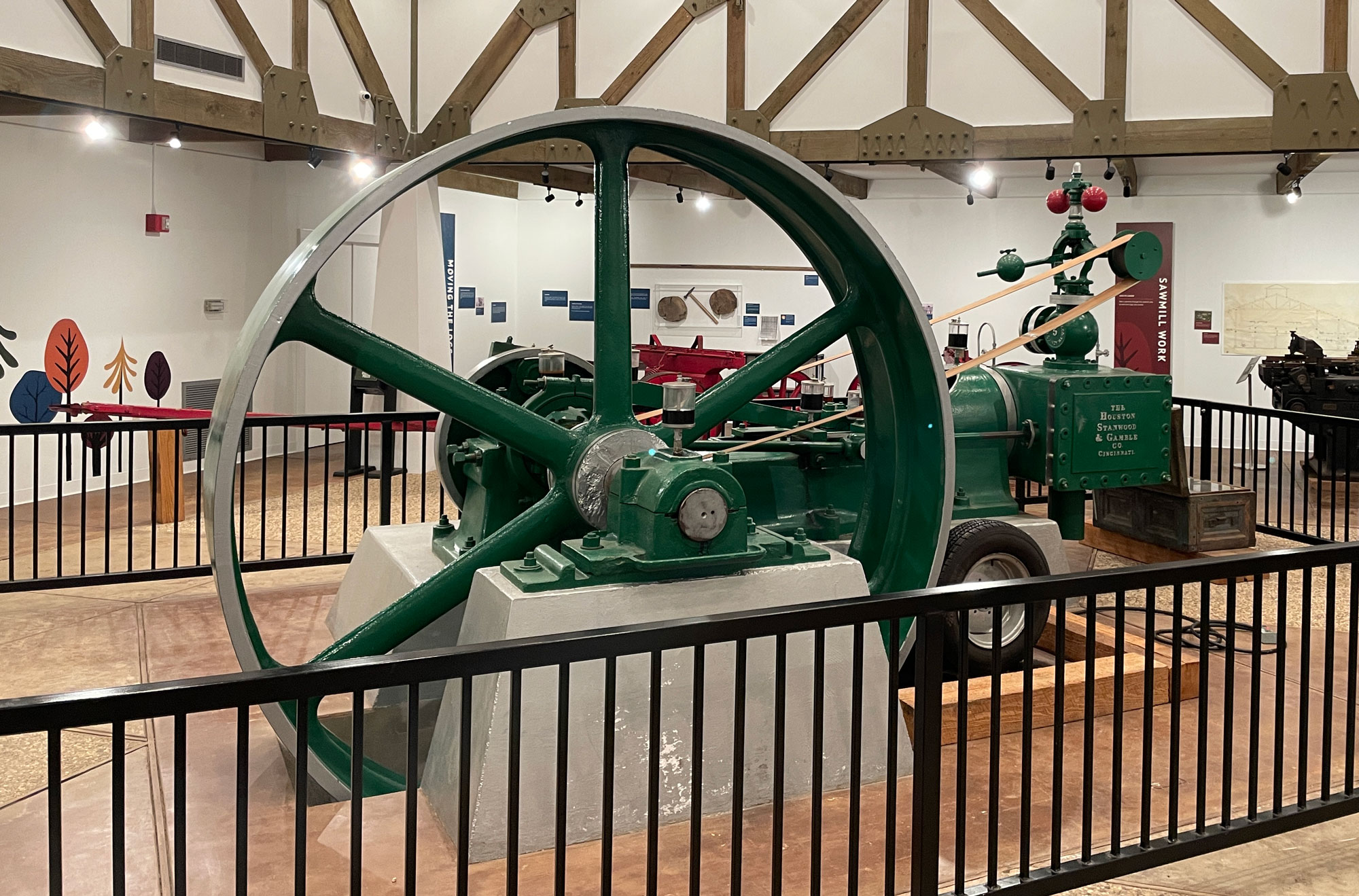 A green metal steam engine inside a black metal fence