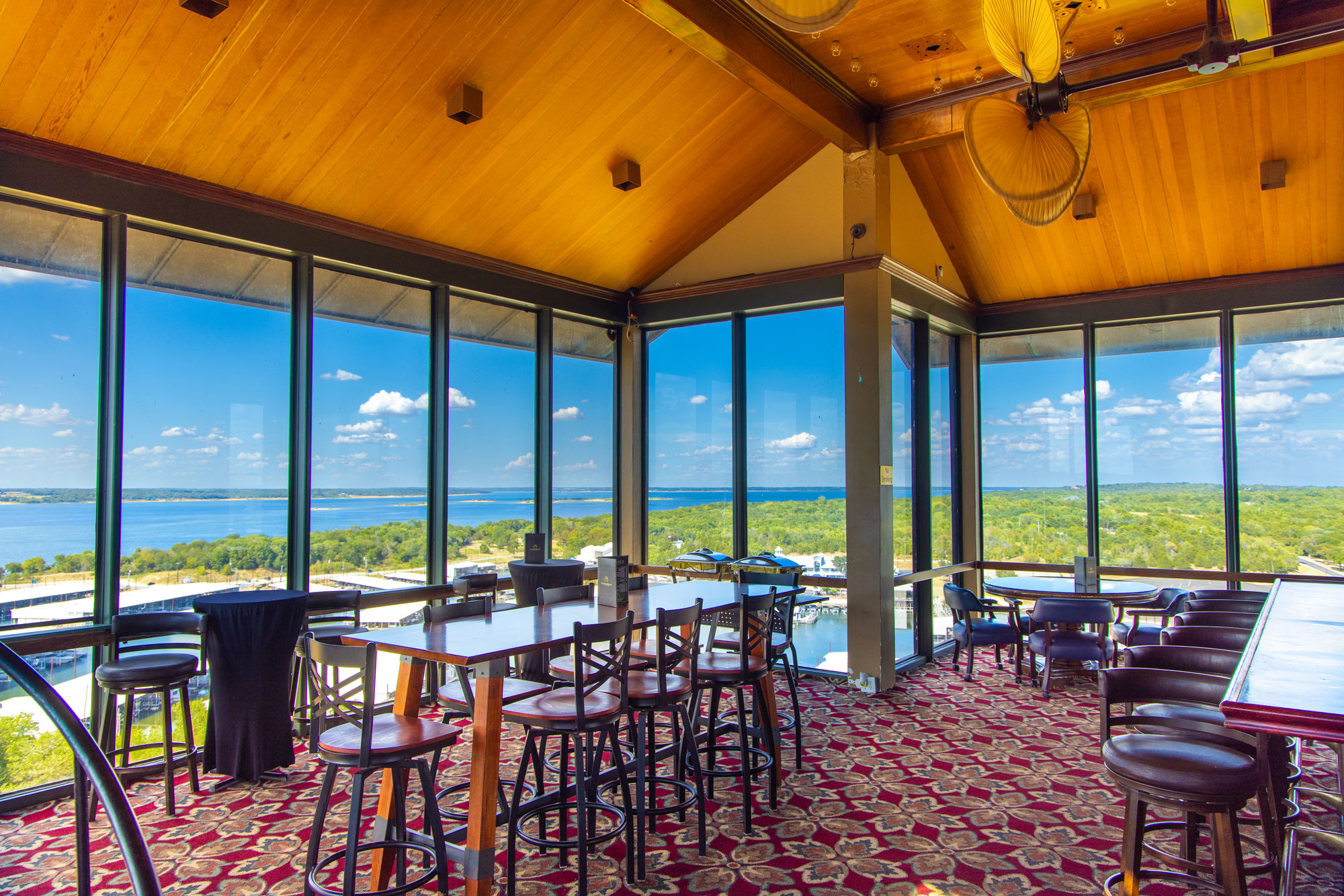 A large bar with panoramic windows and a view of a lake