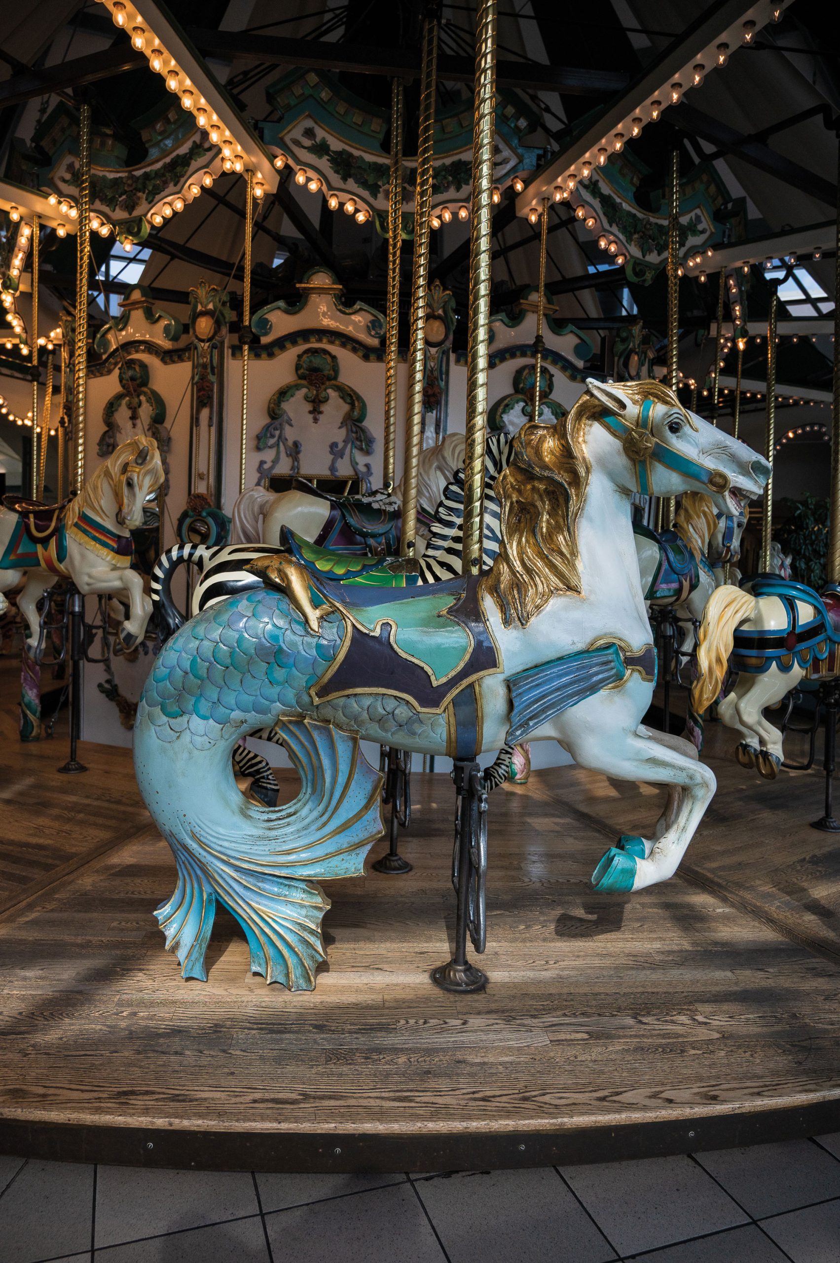 A carousel ride with a half-horse, half-mermaid in front