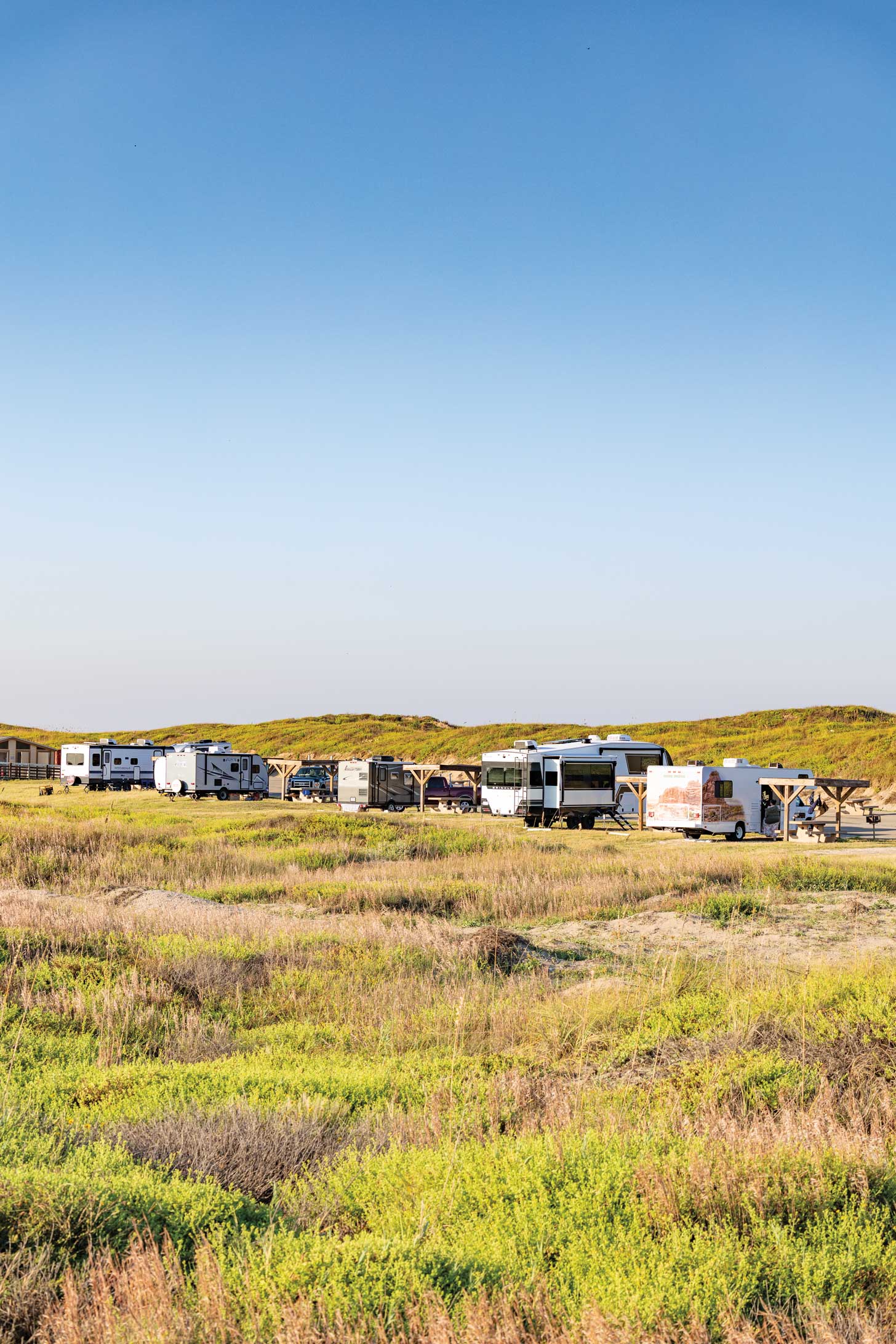 RVs parked in a beachy field