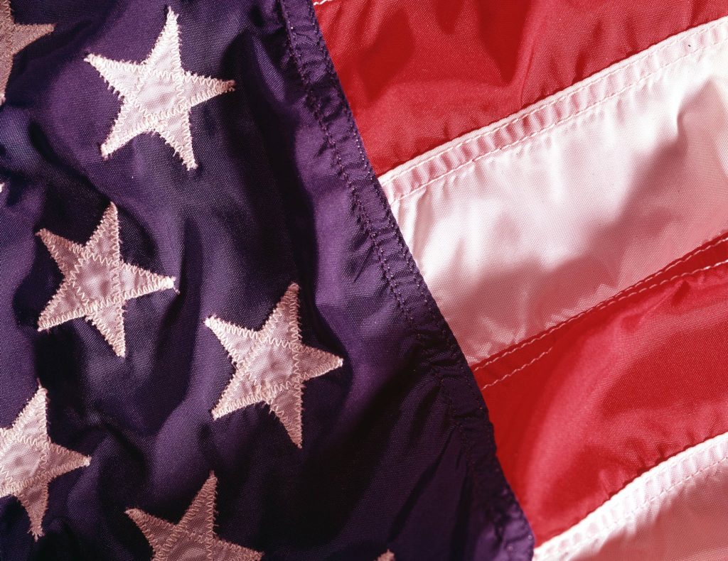 Close-up detail of an American flag with five white stars and a few red and white stripes visible