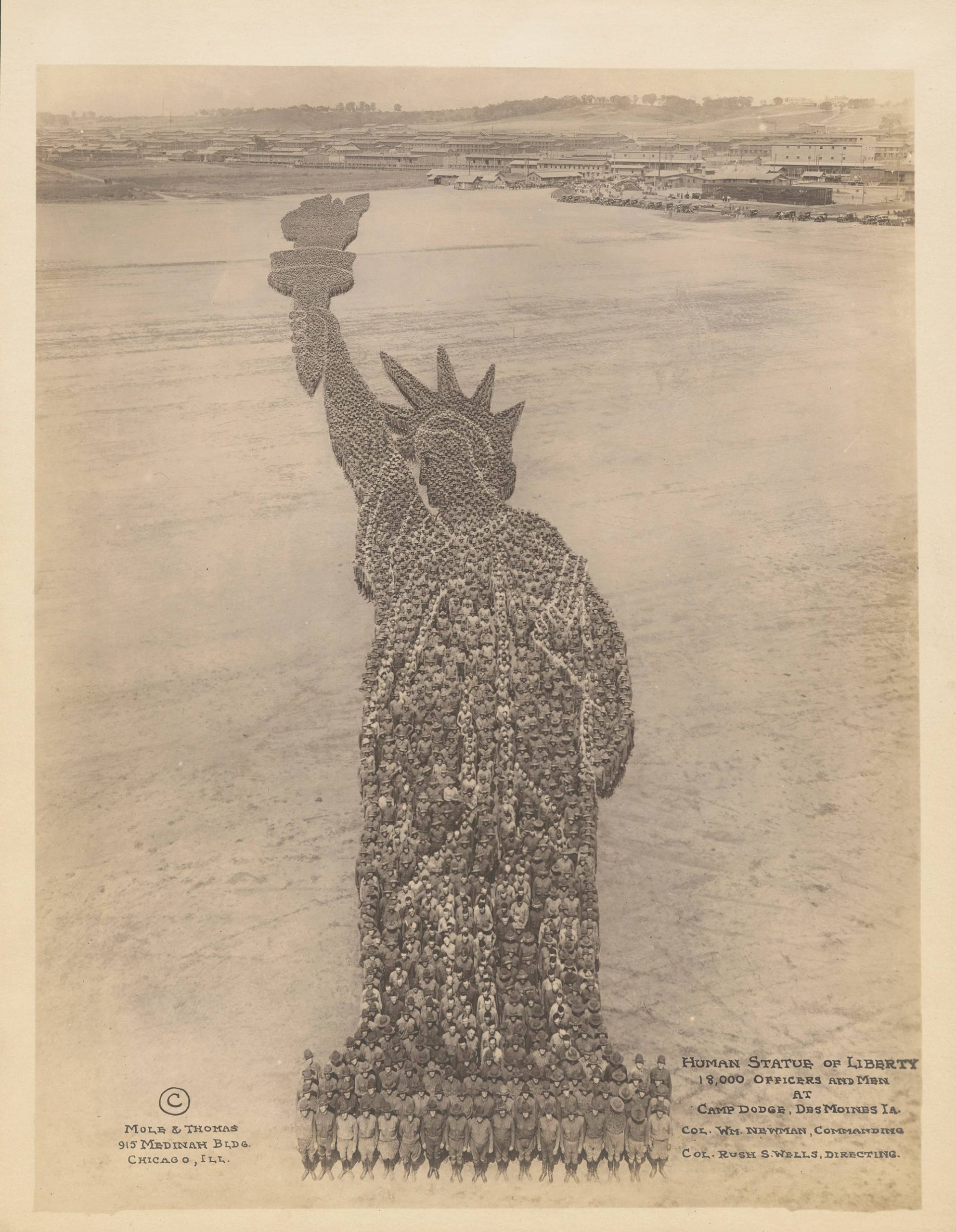 Thousands of people posted together in the shape of the Statue of Liberty