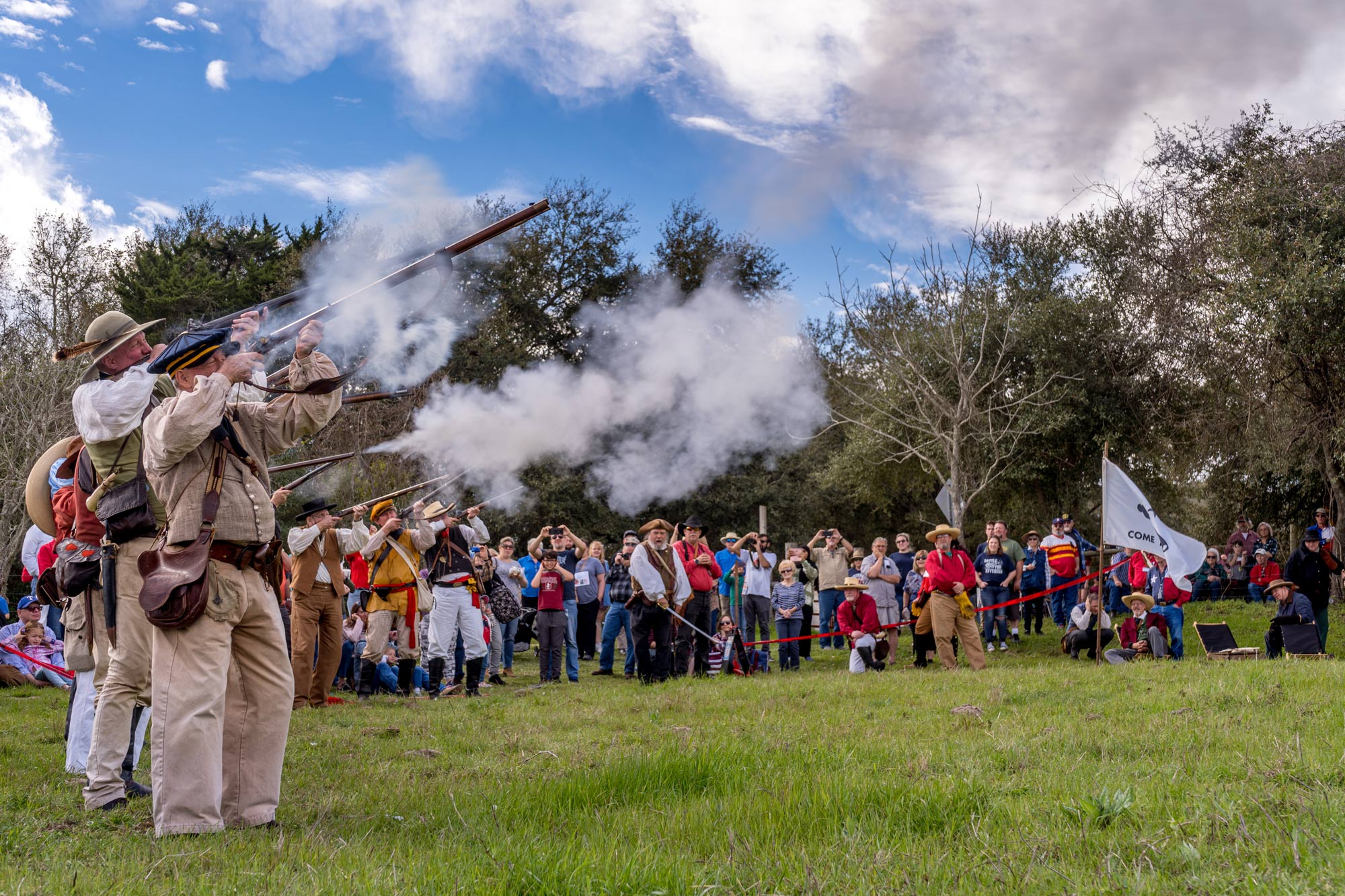 Reenactors in period-specific garb celebrating the birthplace of Texas at Washington-on-the-Brazos by firing guns in the air in front of a crowd 