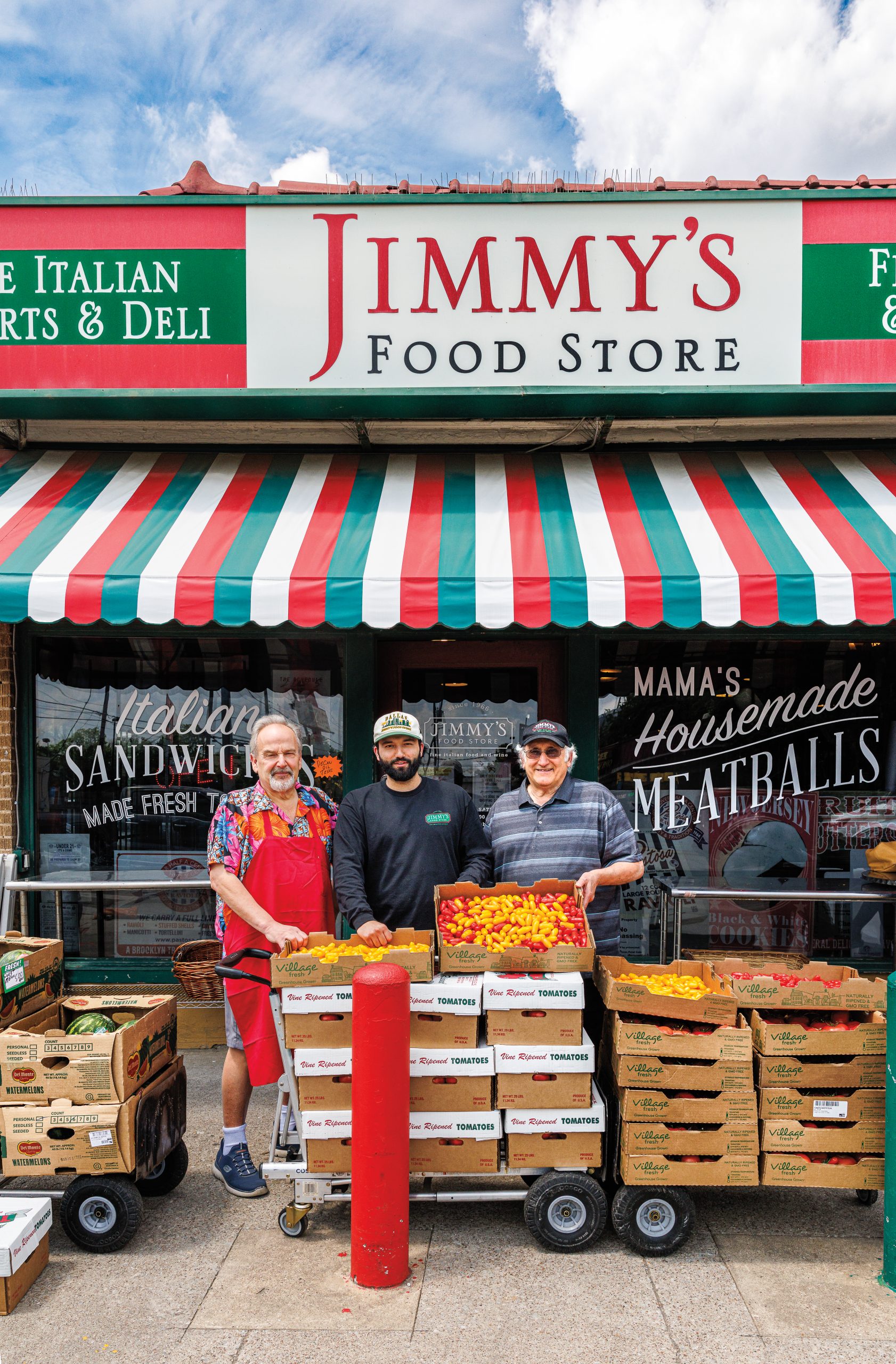 Three men of varying generations stand in front of a green, red, and white storefront that reads "Jimmy's Food Store"