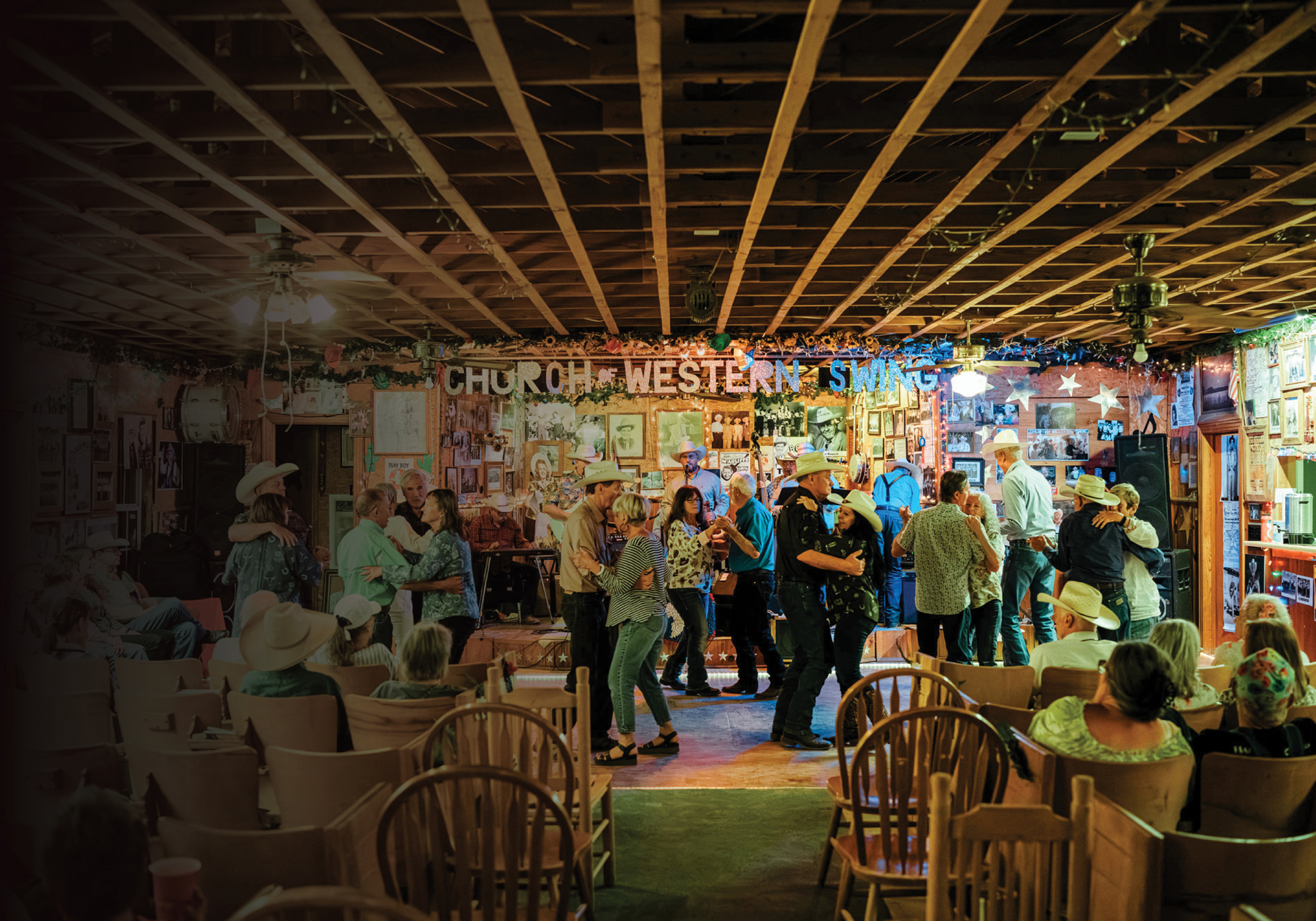 A group of people dancing while people are seated in front of them and a sign reads Church of Western Swing