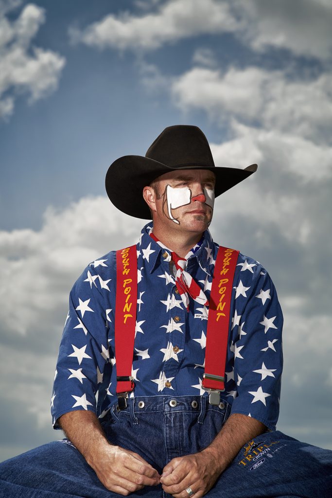 A man dressed as a rodeo clown wearing a cowboy hat and face paint