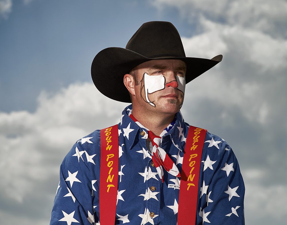 A man dressed as a rodeo clown wearing a cowboy hat and face paint