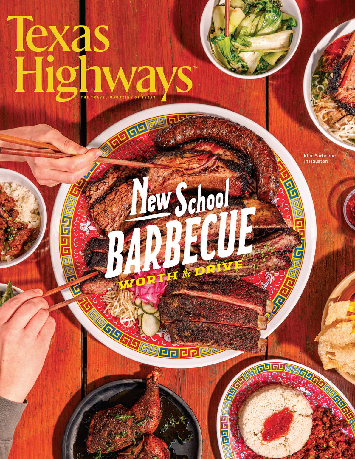 A red table with multiple bowls and plates of food, including greens, rice, and a centerpiece featuring brisket, ribs, and sausage, with two hands holding chopsticks and grabbing food