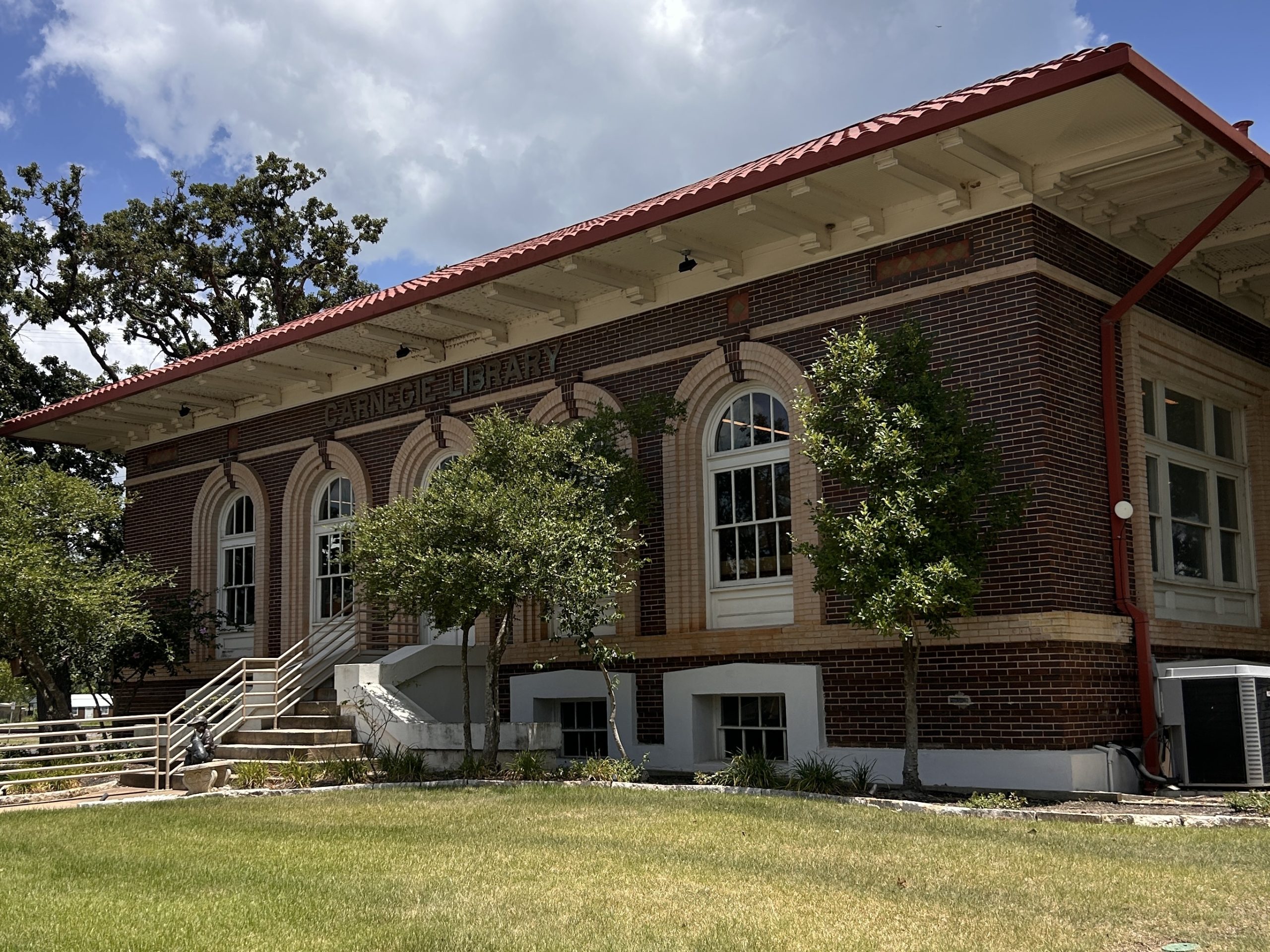 Exterior of the Franklin Carnegie Library, an Italian Renaissance-style building with large windows and an eaved roof with red tiles.