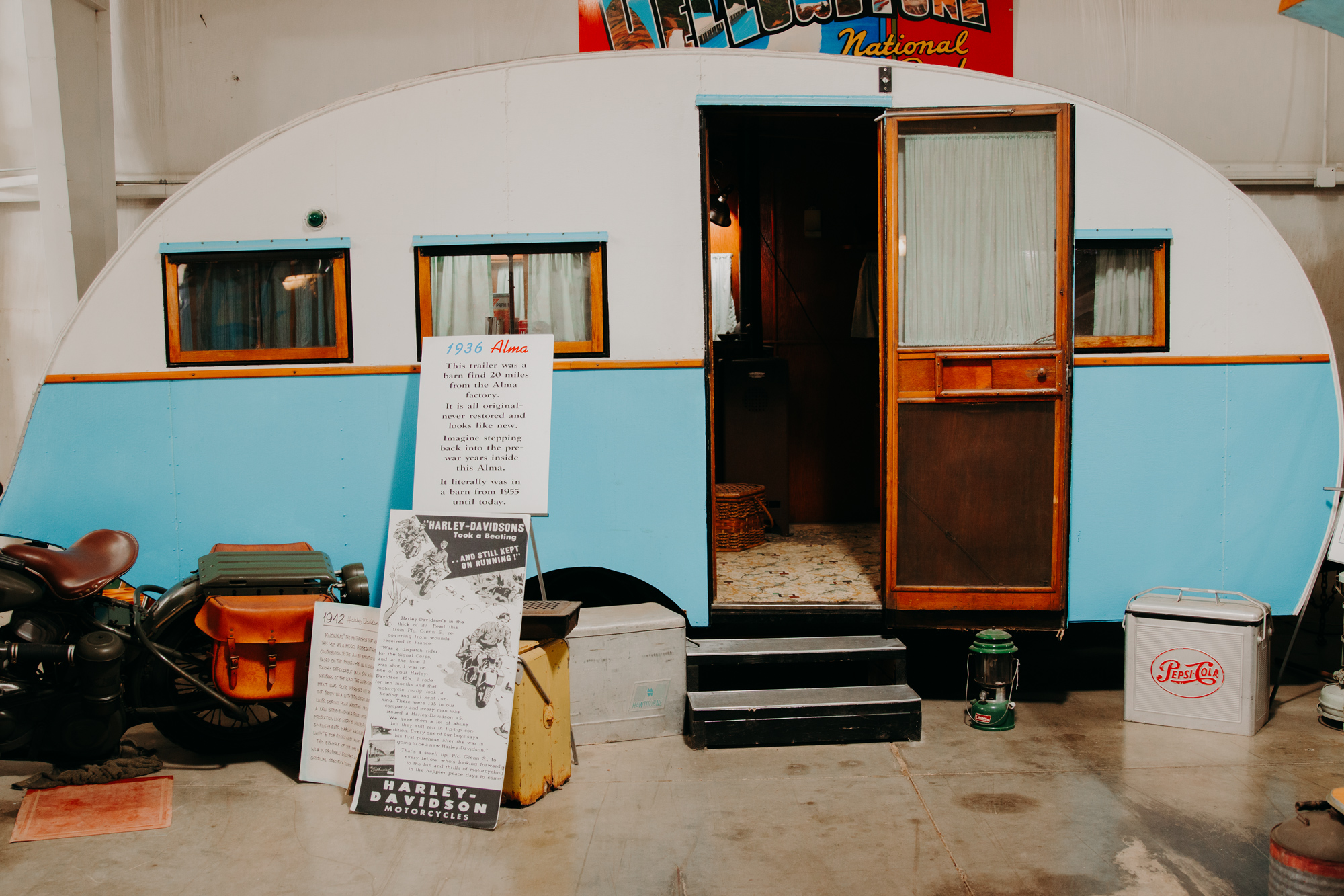 A small white and blue curved trailer with a door open