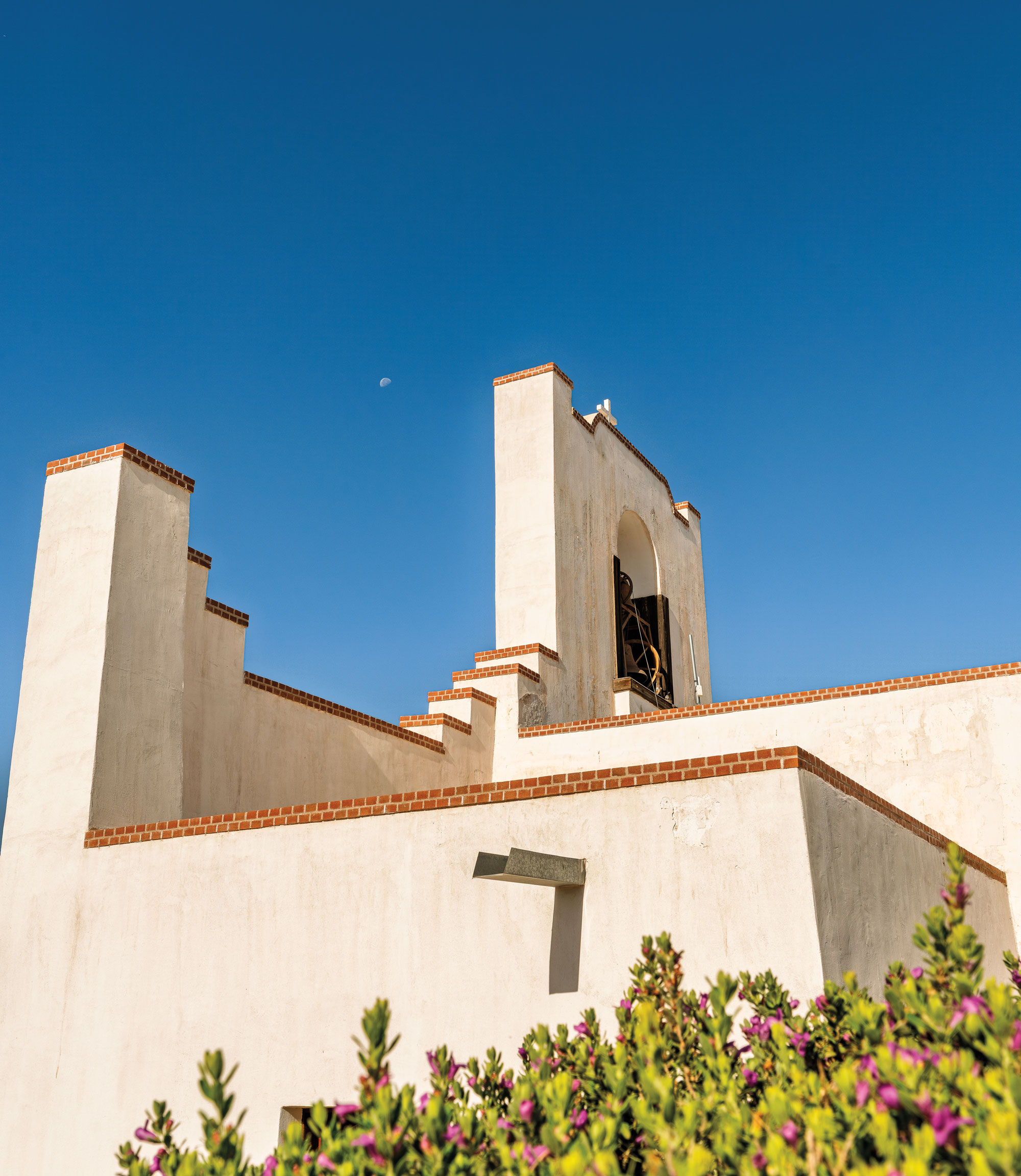 The bell of a white adobe mission