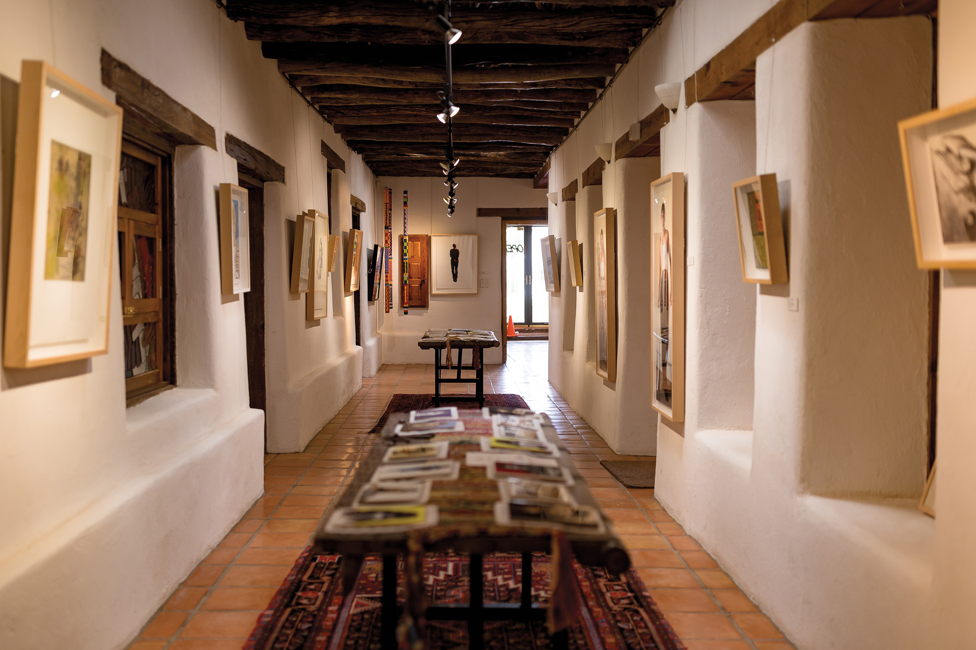 A long hallway with white walls filled with art