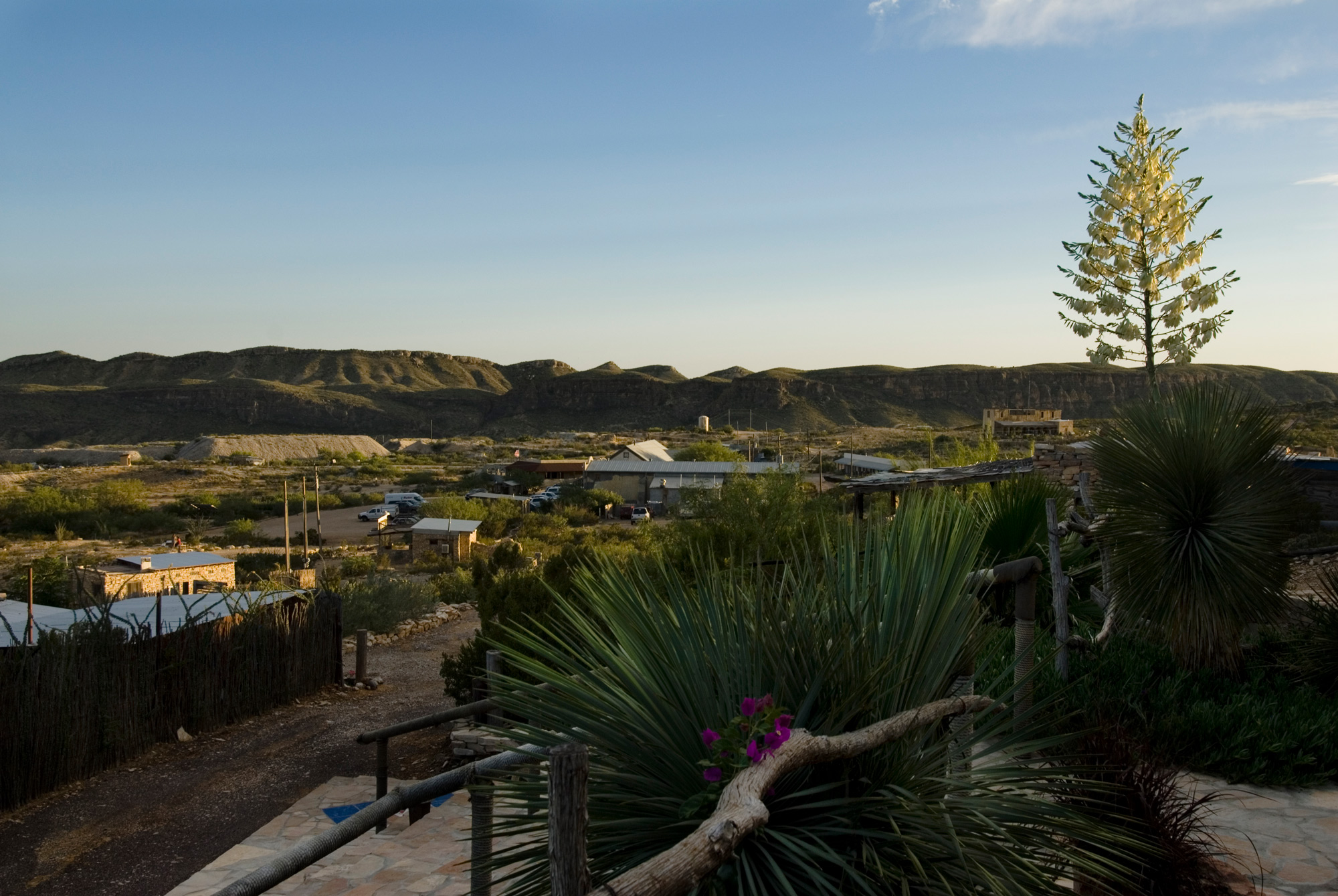 A view of mountains in the distance, with small buildings and cars in front of them