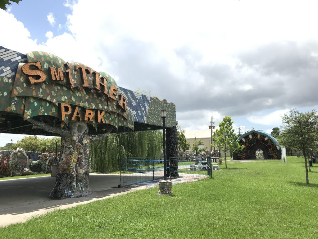 A park with trees and a large sign that reads Smither Park on the left side