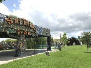 A park with trees and a large sign that reads Smither Park on the left side