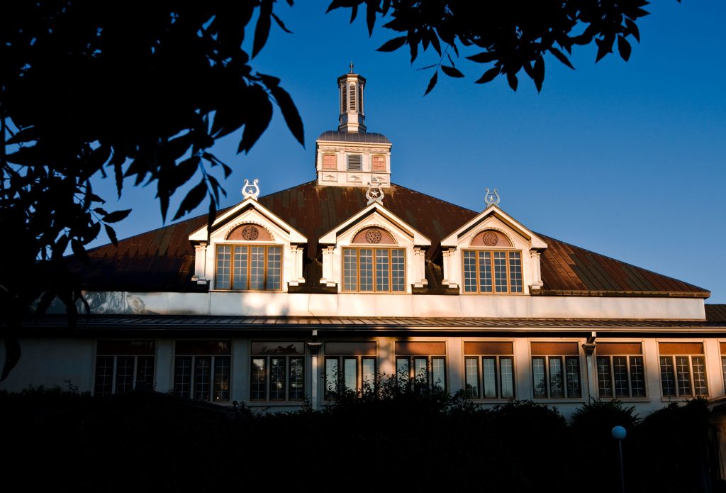 An ornate music hall building framed by a tree